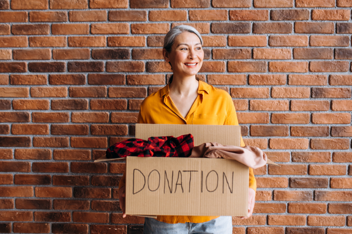 mujer-mayor-sosteniendo-caja-carton-articulos-para-donar